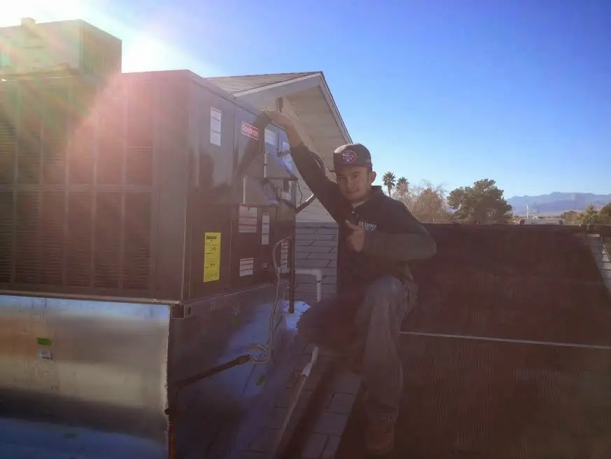 HVAC technician performing Air Duct Repair on a rooftop unit in Madison