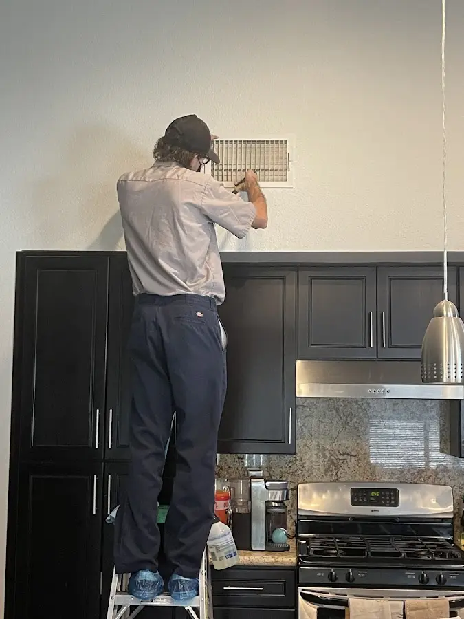 Technician inspecting an air vent during HVAC service in Madison